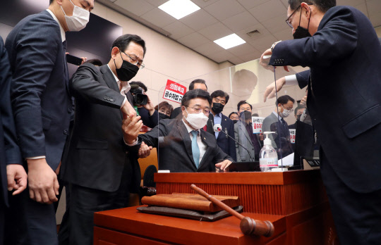 윤호중(왼쪽 세번째) 국회 법제사법위원장이 8일 법제사법위원회 전체회의에서 고위공직자범죄수사처(공수처) 설치 및 운영에 관한 법률 일부개정법률안을 통과시키려 하자 국민의힘 주호영 원내대표와 의원들이 항의하고 있다.    연합뉴스